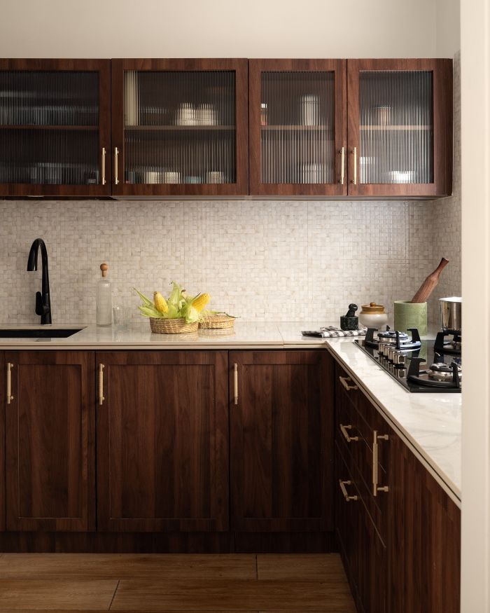 A charming essence of French country style comes to life in this kitchen, featuring shaker-profile cabinets throughout and dado wall tiles with a luminous mother-of-pearl finish; Photography by Nayan Soni