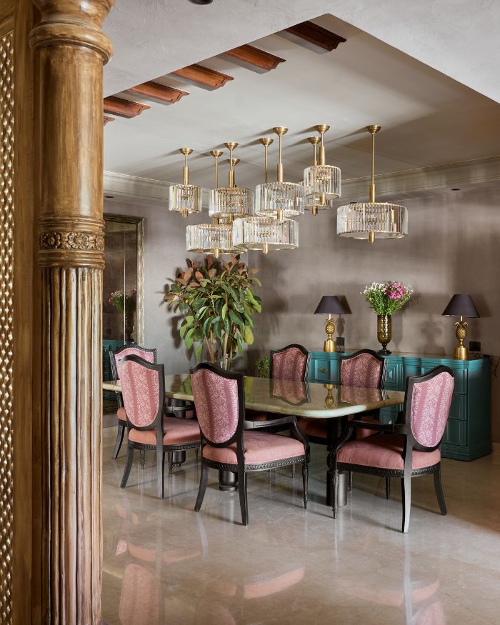 Set beneath a timeless glow, the dining table crowned with green onyx is more than just furniture—it’s a stage for slow meals, deep conversations, and the poetry of togetherness. The warmth of the Baaroq fireplace completes the scene, casting flickering shadows that dance to the rhythm of the stories shared; Photograph by Rohit Mendiratta from The Matter Studio