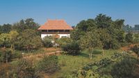 Disassembled and transported piece by piece 
all the way from down south, the house Meda is 
now settled in a quiet village near Sultanpur Bird Sanctuary, Gurgaon. It boasts a Mangalore tiled roof and is surrounded by tropical greenery; Photography by S Thiru
