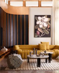 The sun-washed lounge is anchored by the yellow Baxter Banana Boat sofa and rich brown Puffo brass armchairs. A bold Zebra coffee table adds contrast, Mark Catesby’s Laurel Tree (Magnolia altissima) ties the space together; Styled by Fazna Marakkar; Photography by Justin Sebastian