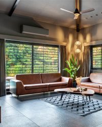 The living room has flooring with full body vitrified tiles, a centre table from Sabandh sales, the ceiling has metalwork by Mahir steel, curtains from Khandelwal, while the sofa and chair are customised on site; Photography by Tejas Shah