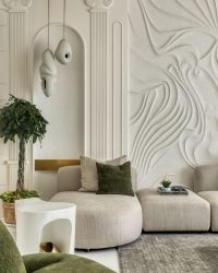 The space pays homage to Greek-inspired design with its fluted columns and arch motifs, while a bespoke, hand-sculpted wall texture, flowing like fabric caught in motion, adds an unexpected, artistic twist. Lighting and furniture are customised and the plant is by Sparrow Design;  Photography by Pulkit Sehgal
